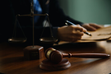 Business and lawyers discussing contract papers with brass scale on desk in office. Law, legal services, advice, justice and law concept picture with film grain effect