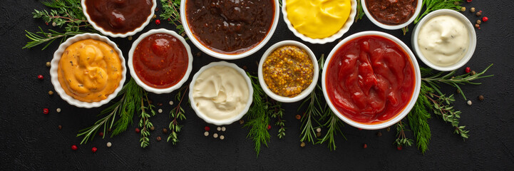 Different types of sauces in bowls with seasonings banner, rosemary and dill, thyme and and peppercorns, top view, copy space