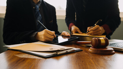 Business and lawyers discussing contract papers with brass scale on desk in office. Law, legal services, advice, justice and law concept picture with film grain effect