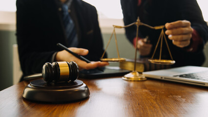 Business and lawyers discussing contract papers with brass scale on desk in office. Law, legal services, advice, justice and law concept picture with film grain effect