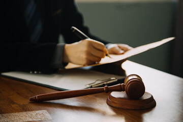 Business and lawyers discussing contract papers with brass scale on desk in office. Law, legal services, advice, justice and law concept picture with film grain effect