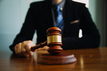 Business and lawyers discussing contract papers with brass scale on desk in office. Law, legal services, advice, justice and law concept picture with film grain effect
