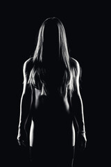 retrato en clave baja de una mujer de frente a la camara sobre fondo negro y en blanco y negro