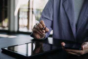 Asian colleagues man and woman discussing and working with laptop computer on office desk in the office