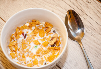 Top view on the white bowl full of corn flakes.