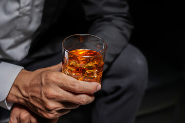 Closeup businessmen holding a glass of whiskey