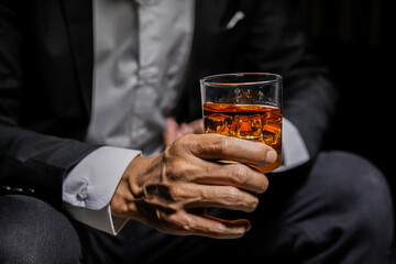 Closeup businessmen holding a glass of whiskey