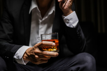 Closeup businessmen holding a glass of whiskey