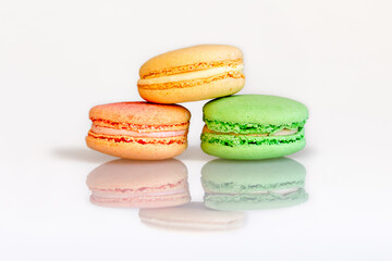 French macarons on a white plastic background with reflection .Macaron cookies