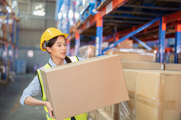 Staff working in large depot storage warehouse lift up heavy carton box to shelf