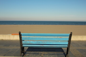 Fototapeta na wymiar An alone bench in front of the sea view