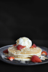 Yummy ice cream, pancakes with strawberries and slithered almonds