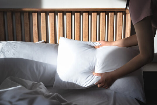 A hotel employee is tidying up the bedding