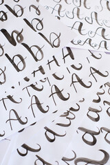 Several white sheets with calligraphic exercises. Calligraphy practice.