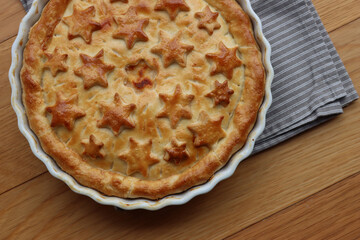 Italian Timballo or Timbale filled with pasta and bechamel with tomato sauce on wooden table