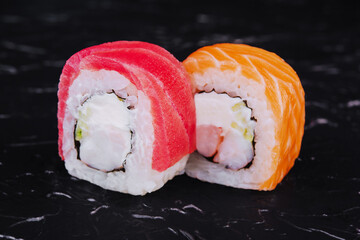 tuna and salmon sushi rolls on black