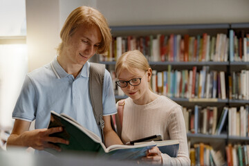 Two friends student chooses books while standing in the university library . Education concept