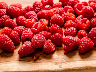 Fresh raw raspberry on wooden board and white isolated background. Fruit product for sale.