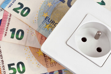 Concept de d&eacute;penses d'&eacute;lectricit&eacute; avec une prise &eacute;lectrique sur des billets de banque en euros