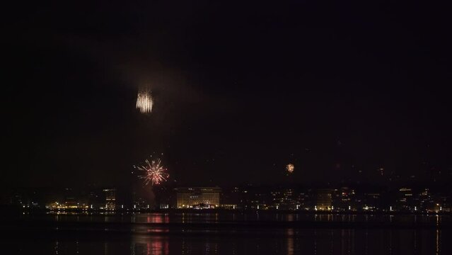 Real fireworks above large residential area landscape at night. New Years Eve pyrotechnics at Thessaloniki, Greece seen from the city waterfront.