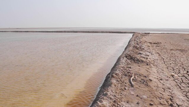 View of salt pans at Little Rann of Kutch, Gujarat, India. Salt pans where water gathers and leaves a deposit of salt on evaporation.
