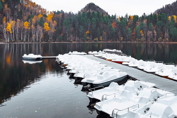 White catamarans on a picturesque lake waiting for tourists. Gold autumn.