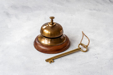 Fototapeta na wymiar Golden hotel service bell with key on reception desk
