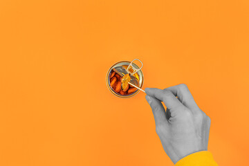 Hand picking pickled mussels out of the can with toothpick. Orange background. pop art style