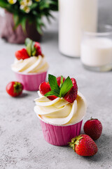 Vanilla cupcake with white cream and strawberries