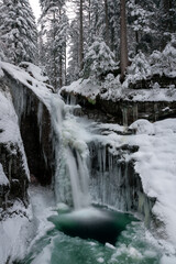 Vereister Wasserfall im Winter bei Schnee im Bayerischen Wald.