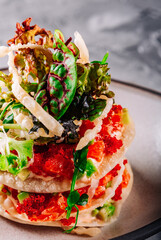 Millefeuille with salmon, caviar and avocado on dark background