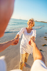 Happy Old Retired Senior Couple Dancing Holding Hands on a Beach - 558118830
