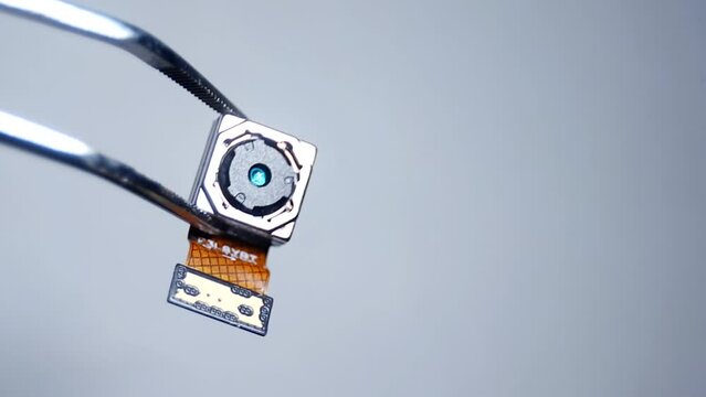 holding and replace tiny small smartphone camera module with tweezers
