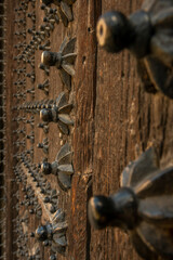 Old wooden street door with hundreds of decorative studs