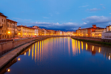 Fototapeta na wymiar Panoramic view of the old town of Pisa and the Arno river at twilight, Italy. Night cityscape