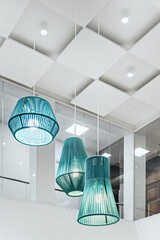 Decorative blue rope lamps in an office with plasterboard decoration on the ceiling