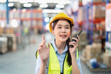 Staff in large storage warehouse use radio walkie talkie explain material storage location to team