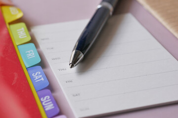 weekly planner and notepad on table 