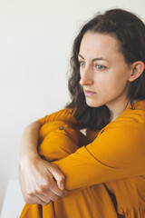 Fototapeta premium Portrait of a pensive woman in a yellow dress