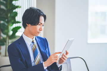 休憩中にタブレットを操作するビジネスマン