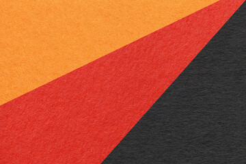 Texture of old craft red, black and orange color paper background, macro. Vintage abstract cardboard