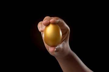golden egg in the hand isolated on black