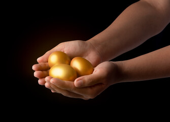 golden egg in the hand isolated on black