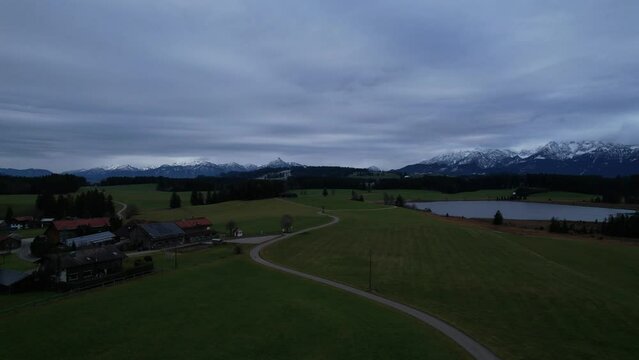 DRONE AERIAL FOOTAGE: Winter view from the Allgau Alps mountain range in the Northern Limestone Alps and alpine lake Attlesee, located near Nesselwang town, Bavaria, Germany.