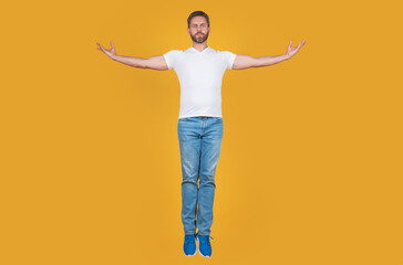 Handsome man levitating yellow background. Grizzled guy levitating midair. Levitating and hovering