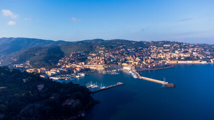Fototapeta premium Top view of the small town of Porto Santo Stefano, Tuscany Italy at sunset. Harbor with boats, fishing boats, emerald coast and city