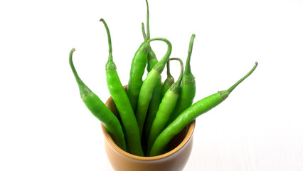Fresh long Indian green chillies on wooden background.