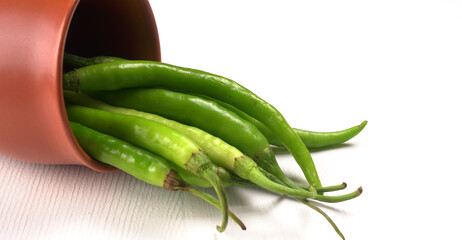 Fresh long Indian green chillies on wooden background.
