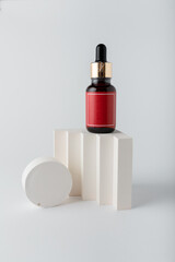 Face skin care cosmetics. Bottle of azelaic or hyalurone acid on white background, decorative concrete elements. Mock up, copy space, vertical