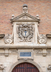 View of ancient stone carving with cross, cherubs and garland above entrance door to the ancient...